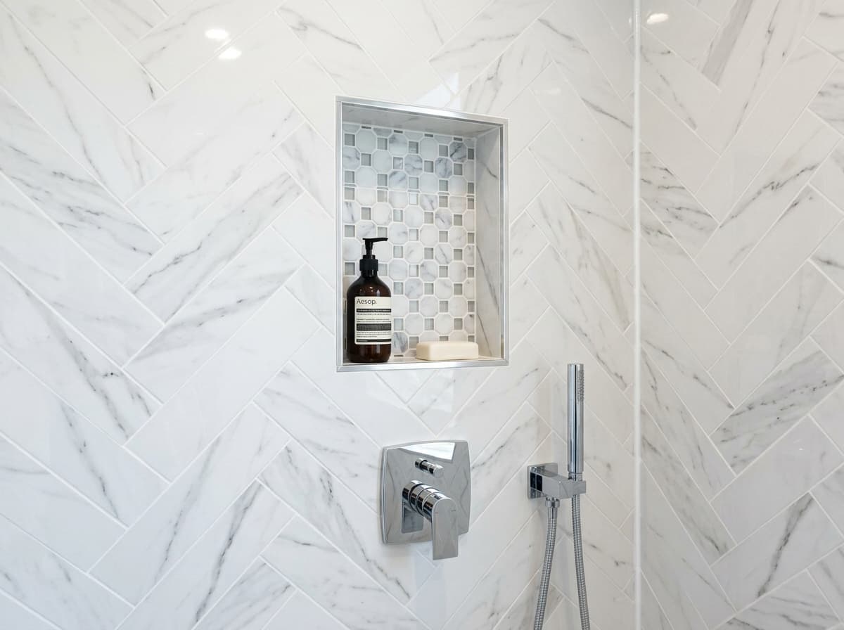 Herringbone marble shower with decorative niche detail